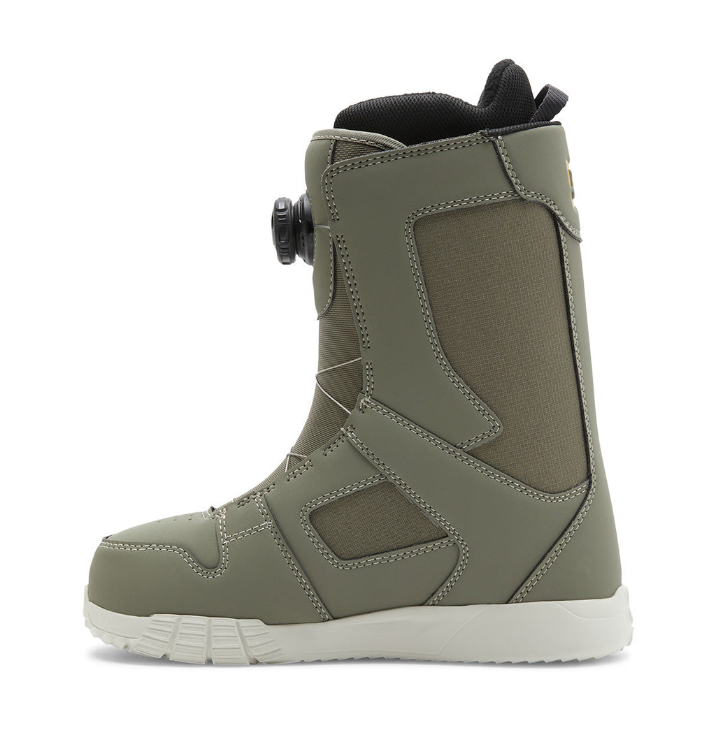 A side view of a single olive green DC Shoes Women’s Phase BOA® Snowboard Boot is shown against a white background, highlighting the advanced BOA® Fit System dial lacing, dark mesh panels, black inner lining, and white sole. This boot combines high-performance features with comfort for your time on the slopes.