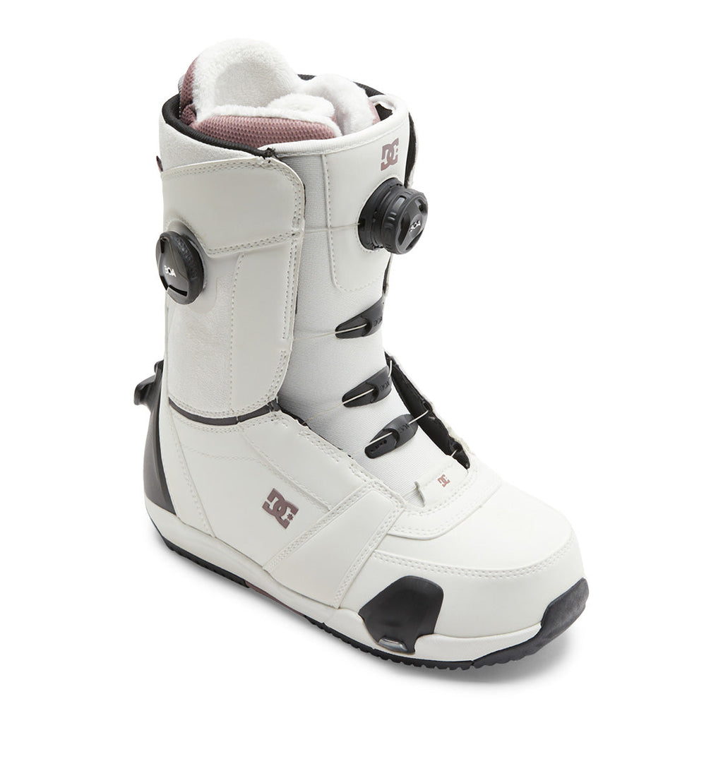 The DC Shoes Women’s Lotus Step On® Snowboard Boots showcase a white and black design with a Dual Zone BOA Fit System for precise adjustability, a black sole, padded interior, and the DC Shoes logo on the side.