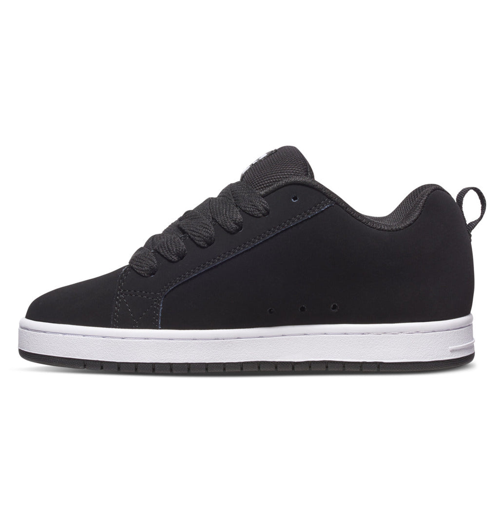 The Men’s Court Graffik Shoes by DC Shoes are shown in a side profile view on a white background. This low-top sneaker features a black upper, white sole, black laces, and a heel pull tab. The iconic DC logo and signature puffy silhouette complete the classic Court Graffik design.