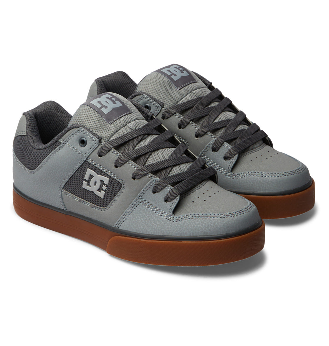 A pair of Men’s Pure Shoes by DC Shoes, featuring a gray colorway with dark gray laces, mesh accents, white DC logos on the sides and tongues, and durable brown rubber soles, are displayed side by side on a white background. Designed for both style and support, these versatile DC Shoes are an excellent choice for those seeking comfortable men’s footwear.