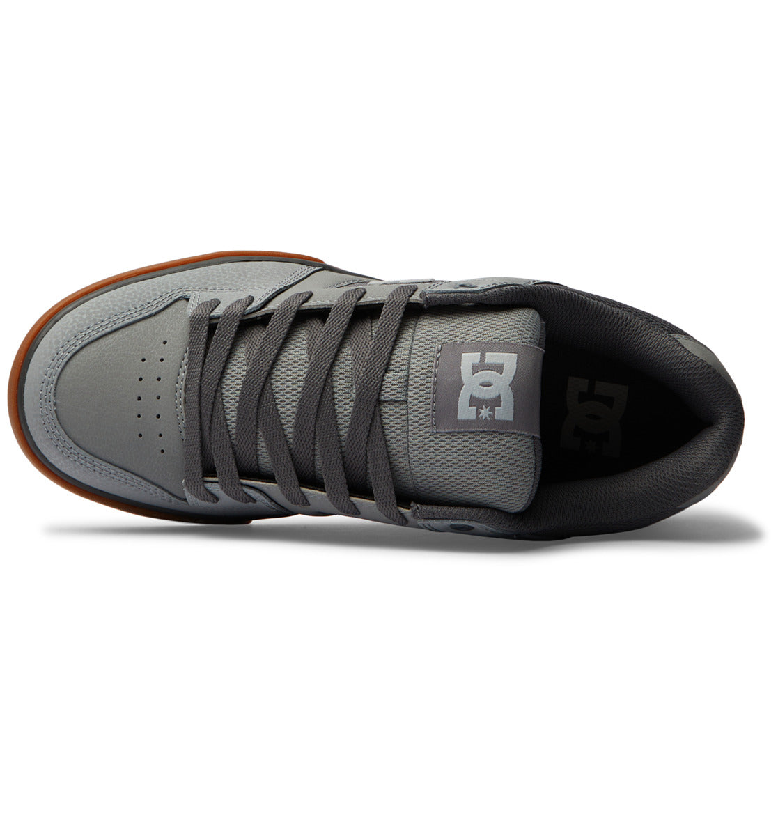 Top view of the Men’s Pure Shoes by DC Shoes, featuring a gray upper with dark gray laces and a brown outsole. The tongue displays a white DC logo with a star, while perforations near the toe enhance breathability, making these some of the most comfortable men’s shoes for everyday wear.