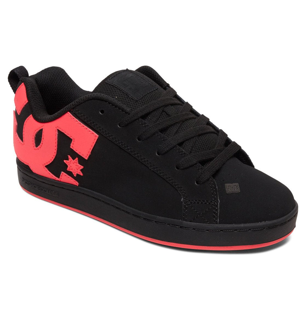 Women’s Court Graffik Shoes by DC Shoes, featuring a ’90s-inspired chunky sneaker silhouette and low-top design. This black women’s sneaker has a bold red sole, black laces, and a striking red DC Shoes logo on the side. Displayed at an angle against a white background.