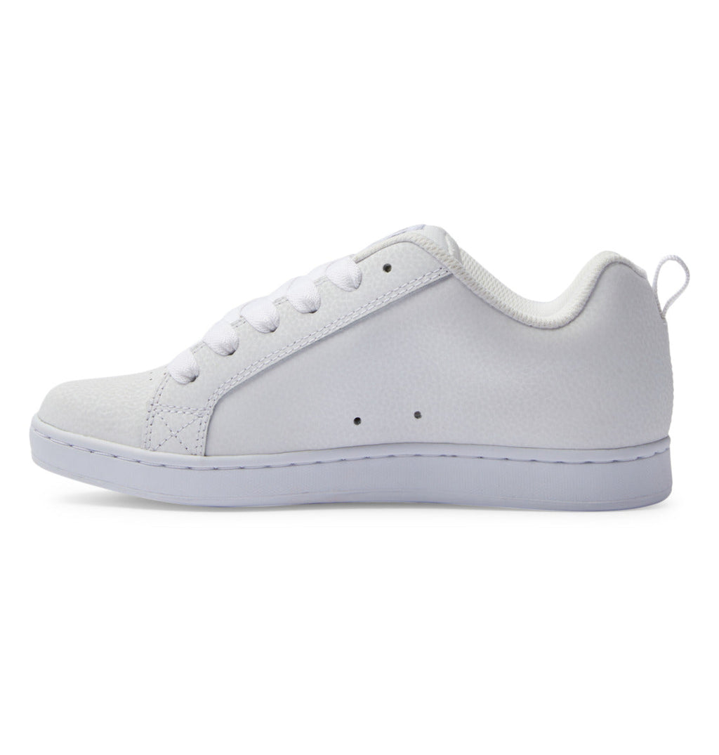 A side view of the DC Shoes Women’s Court Graffik Shoes features a plain white low-top design with white laces, a textured surface, and a white rubber sole. This sleek sneaker channels ‘90s style with a modern twist on the classic chunky silhouette.