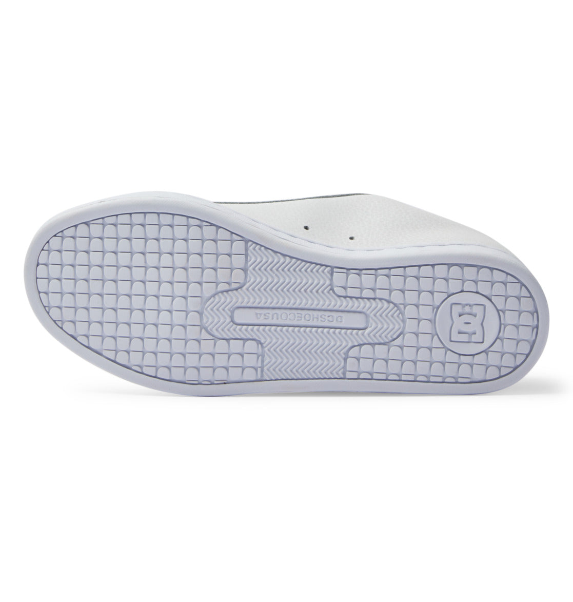 The image displays the bottom view of the DC Shoes Women’s Court Graffik sneaker in white, featuring a textured, grid-like sole pattern and an embossed DC logo near the heel, highlighting the bold, chunky style inspired by ‘90s fashion.