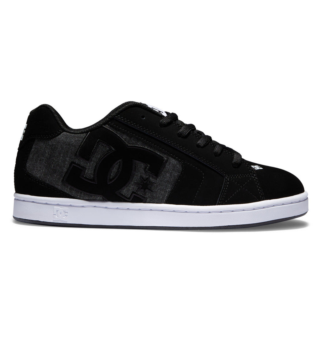 The DC Shoes Men’s Net Shoes feature a black and dark gray design with a prominent DC logo on the side, black laces, and a white rubber sole. Crafted from durable materials for long-lasting wear, this puffy sneaker is displayed from the side against a white background.