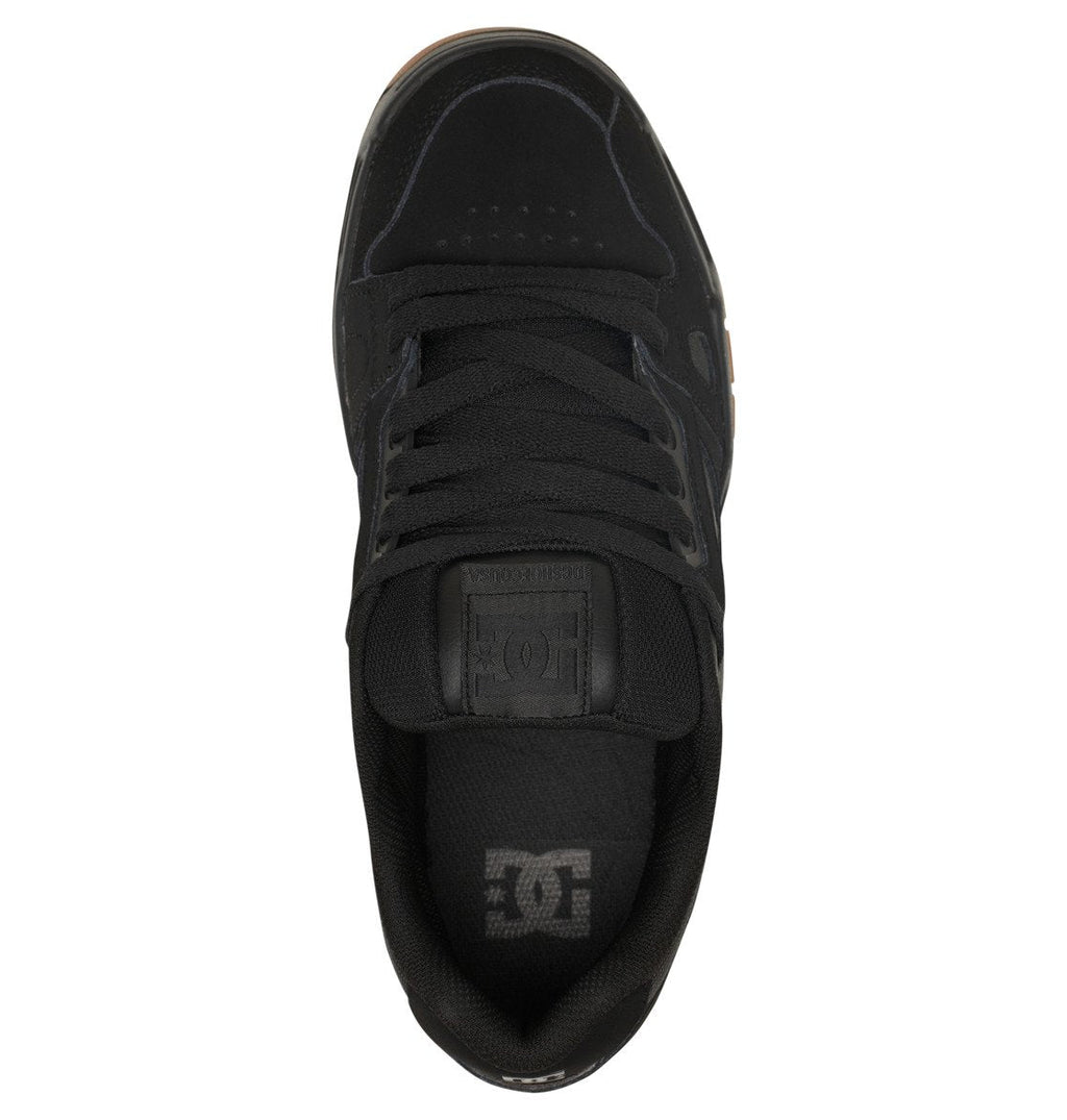 Top view of the Men’s Stag Shoes by DC Shoes in black, featuring black laces, an oversized puff padded tongue, and the DC Shoes logo on both the tongue and insole. This sneaker boasts a durable cupsole construction and showcases a simple, sleek design.