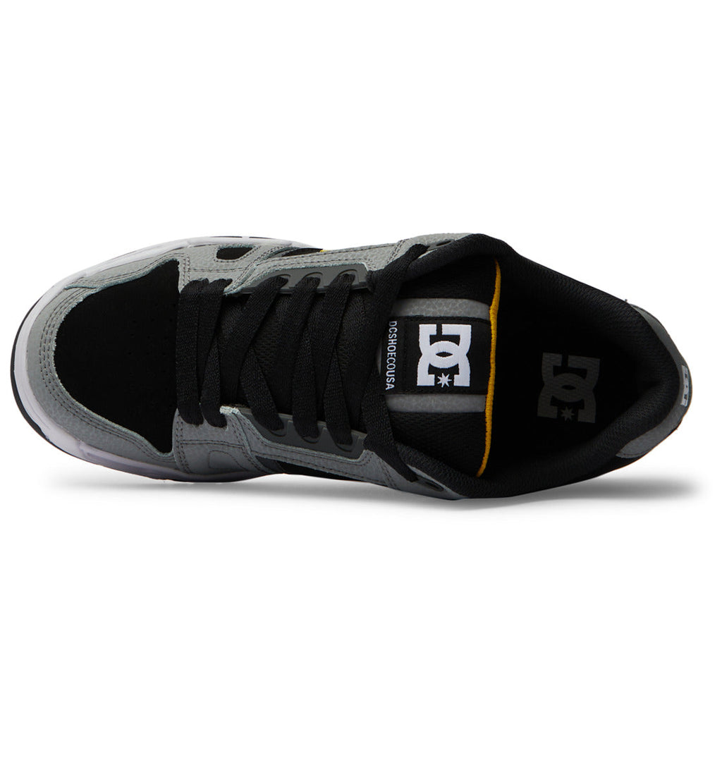 Top view of the DC Shoes Men’s Stag sneaker in black and gray, featuring an oversized puff design, black laces, a black tongue, and a white DC Shoes logo on the insole. The durable cupsole is white with gray and black accents.