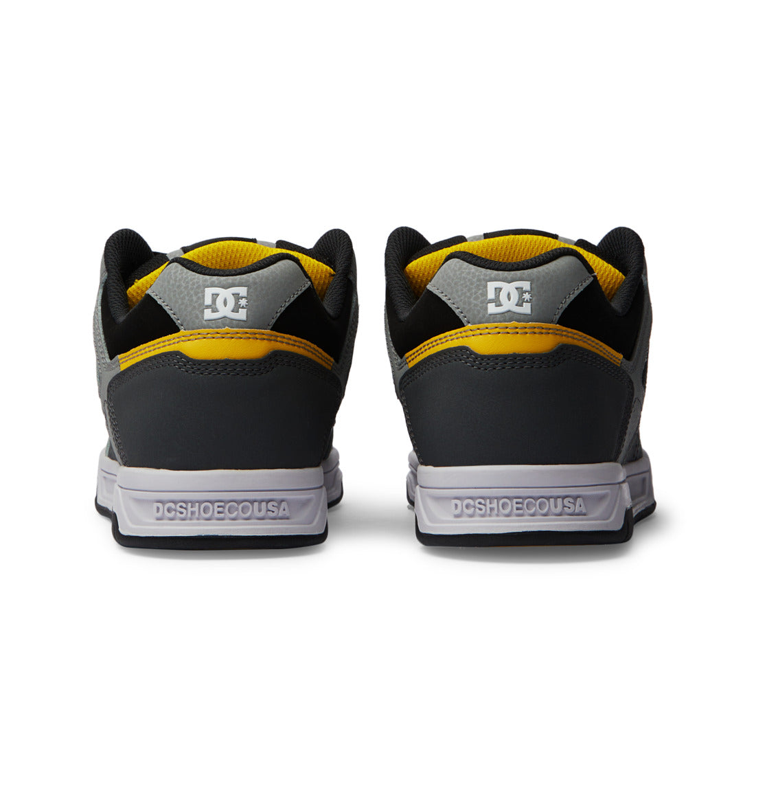 Back view of the men’s Stag Shoes by DC Shoes in black and gray with yellow accents, showcasing an oversized puff design and DCSHOECOUSA branding on the heel. Designed for comfort and style, these sneakers also feature a durable cupsole for lasting wear.
