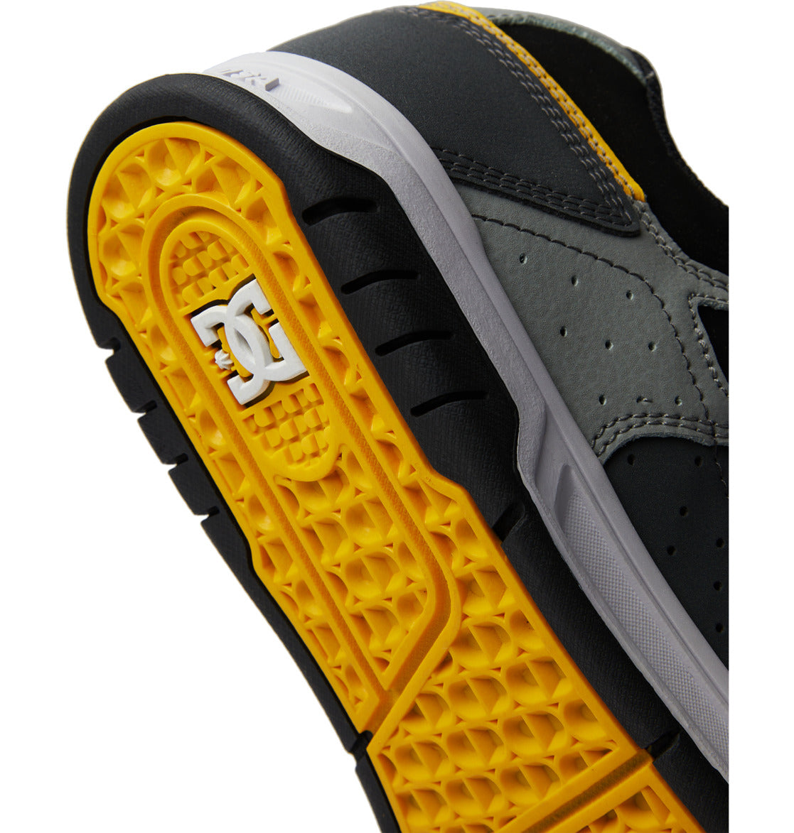 Close-up of the durable yellow and black textured cupsole of the Men’s Stag Shoes by DC Shoes, featuring a white DC Shoes logo, with parts of the gray and black oversized puff upper visible.