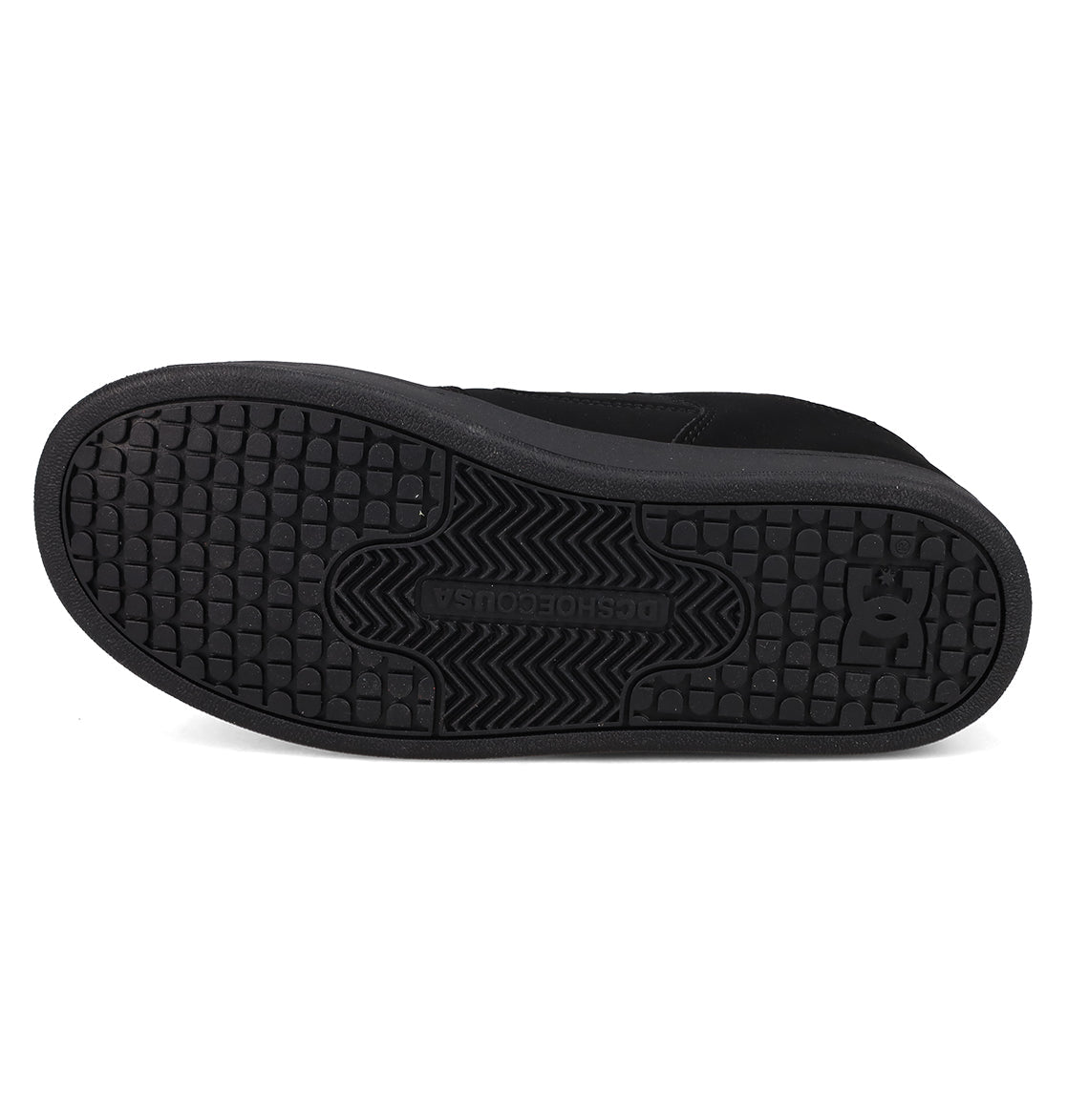 The image displays the black rubber sole of the DC Shoes Kids’ Manteca 4 V Shoes, viewed from the bottom, highlighting the tread pattern and prominent DC logo near the heel—a signature feature of these durable and kid-friendly sneakers from DC Shoes.