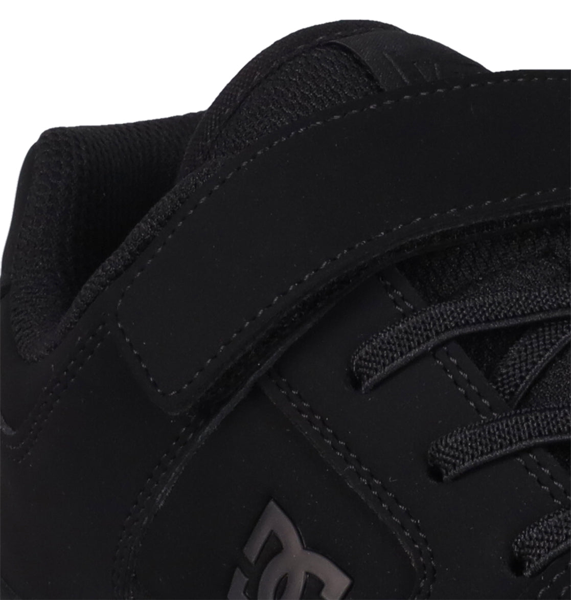 Close-up of a black Kids’ Manteca 4 V Shoe by DC Shoes, highlighting the durable suede or nubuck upper, visible stitching details, laces, and the signature stitched logo on the side—staying true to the classic Manteca skate shoe style.