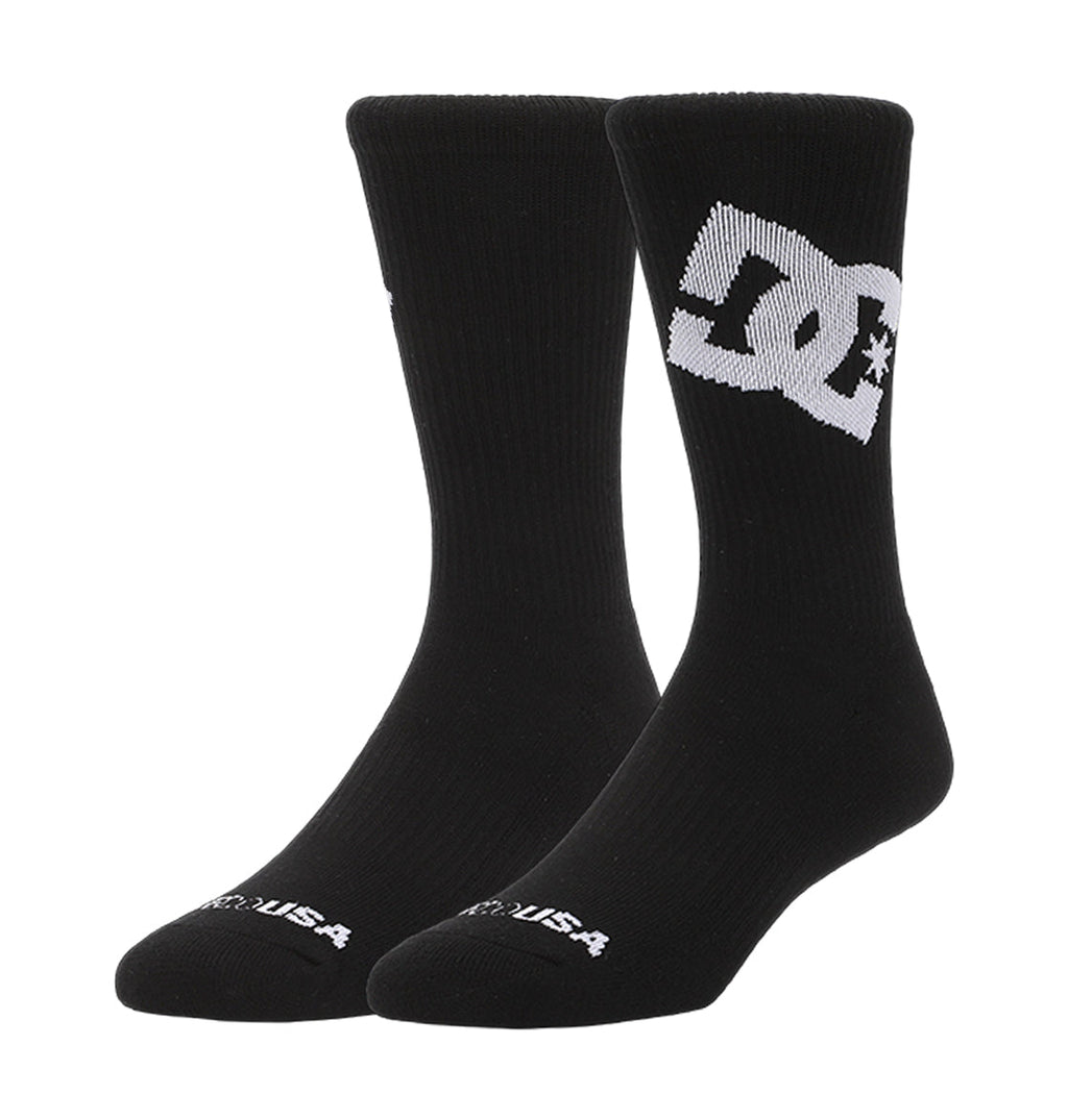The DC Shoes Graffik Logo Crew Socks 3-Pack features black crew socks with a bold white DC Shoes logo on the side, "USA" in white on the toe, and a ribbed texture.