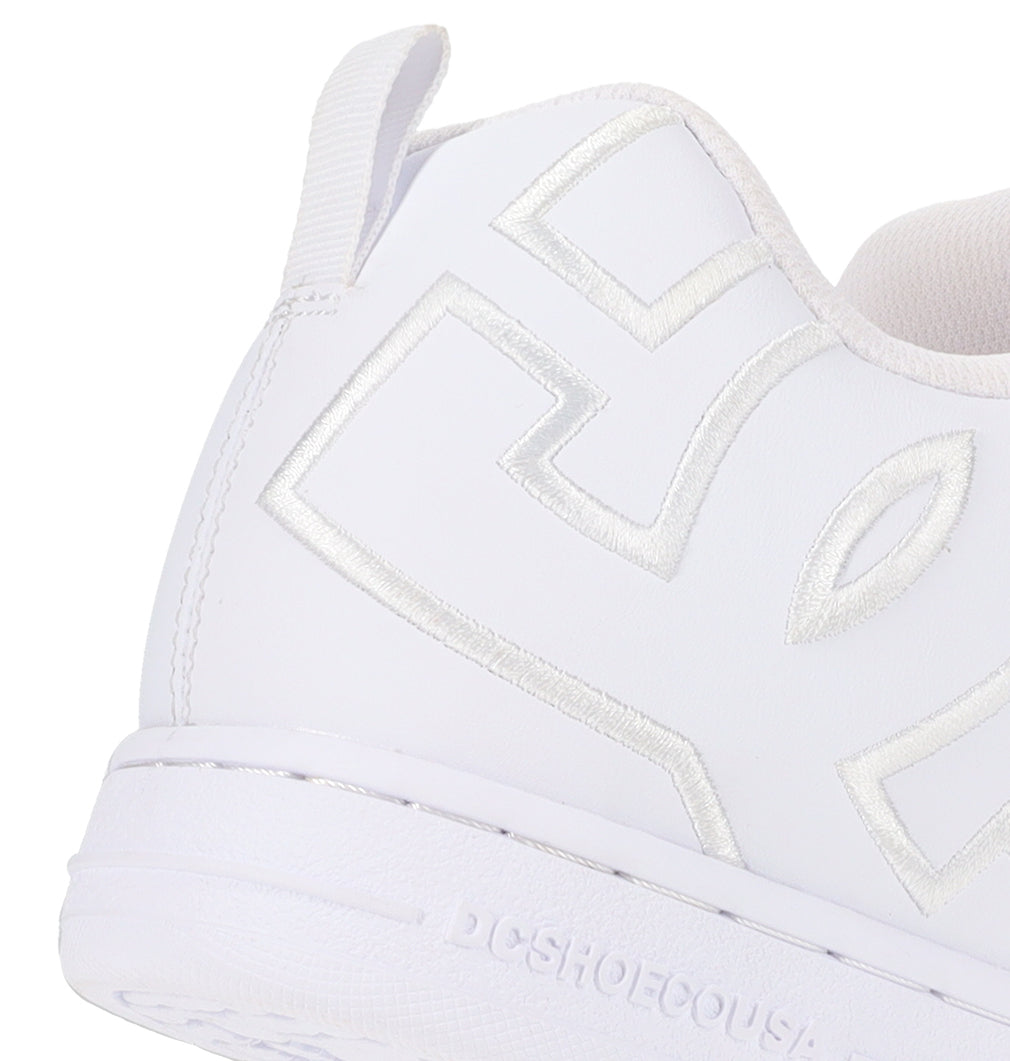 Close-up of the back and side of a white Men’s Court Graffik Shoe by DC Shoes, featuring silver embroidery, visible stitching, and a heel loop. The DC Shoes brand name, DCSHOECOUSA, is embossed on the chunky skate-inspired midsole.