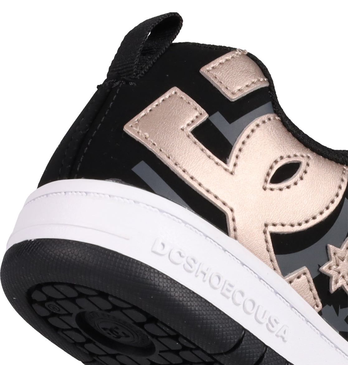 Close-up of the heel of DC Shoes Kids' Court Graffik Shoes in black and gold, featuring a puffy silhouette, white sole with DCSHOECOUSA embossed on the side, and a bold metallic gold DC logo.