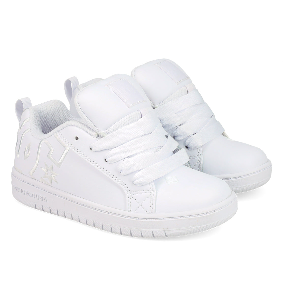 The DC Shoes Kids' Court Graffik Shoes are white low-top sneakers with thick white laces, a chunky sole, subtle embossed logo, and side stitching details, inspired by classic skate styles.
