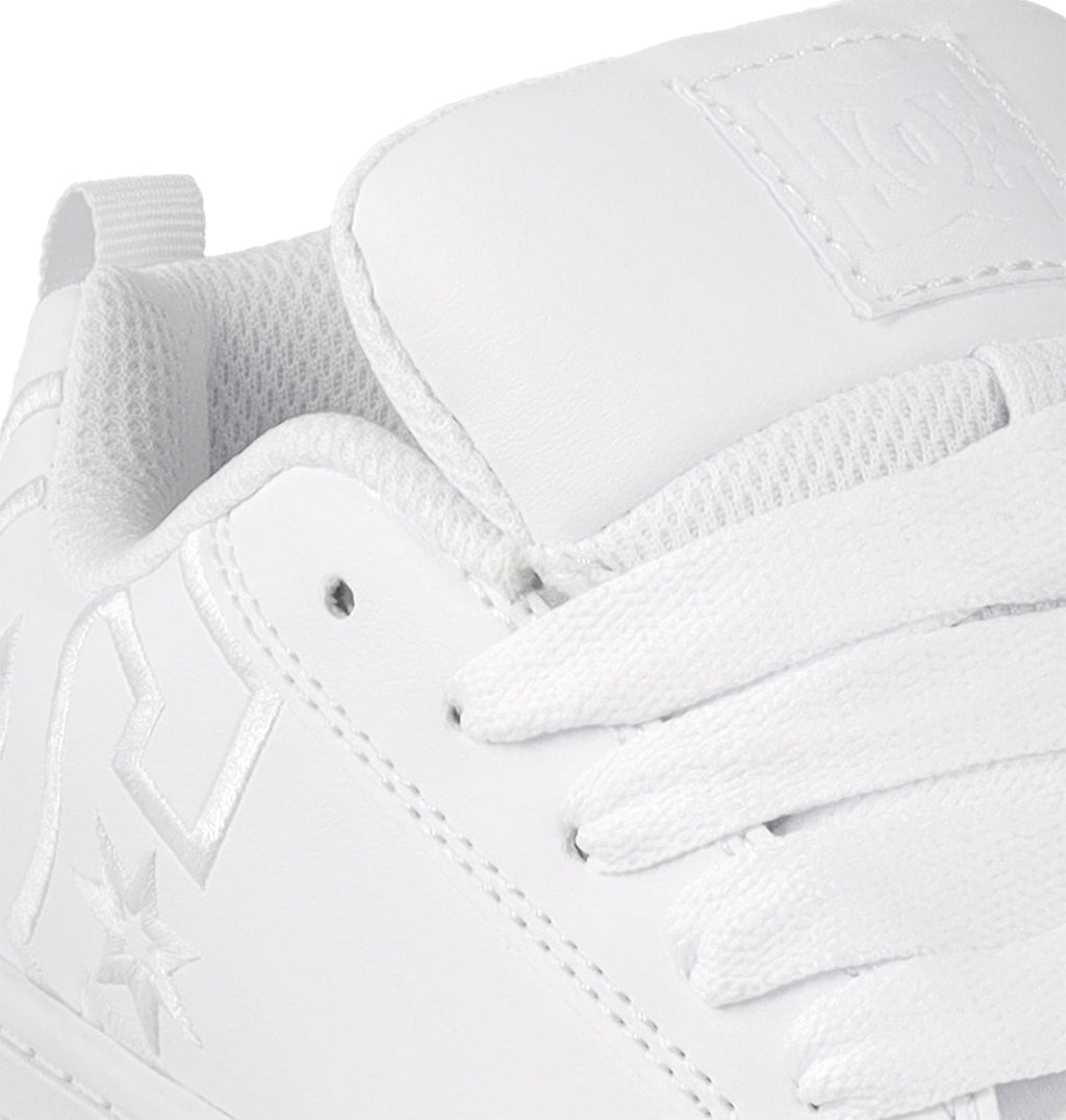 Close-up of the Kids' Court Graffik Shoes by DC Shoes, featuring a white design with textured tongue, white laces, stitched star and geometric logos, plus perforated eyelets—a classic skate-inspired style for kids.
