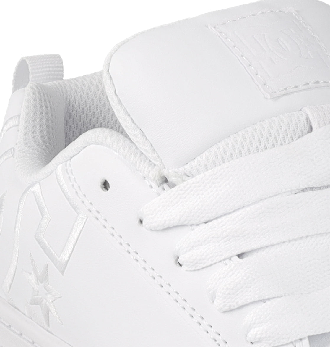 Close-up of the Kids' Court Graffik Shoes by DC Shoes, featuring a white design with textured tongue, white laces, stitched star and geometric logos, plus perforated eyelets—a classic skate-inspired style for kids.