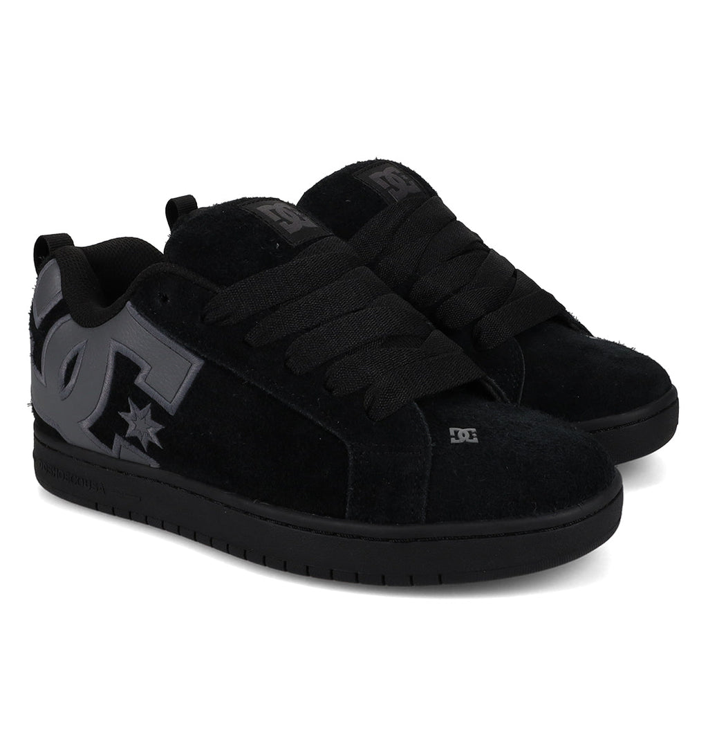 A pair of DC Shoes Men’s Court Graffik Special Edition skate shoes in black, featuring a puffy silhouette, thick black laces, and a large gray DC logo on the side, shown at a slight angle to highlight the outer and front sections of both men’s shoes with a stylish two-tone sole.