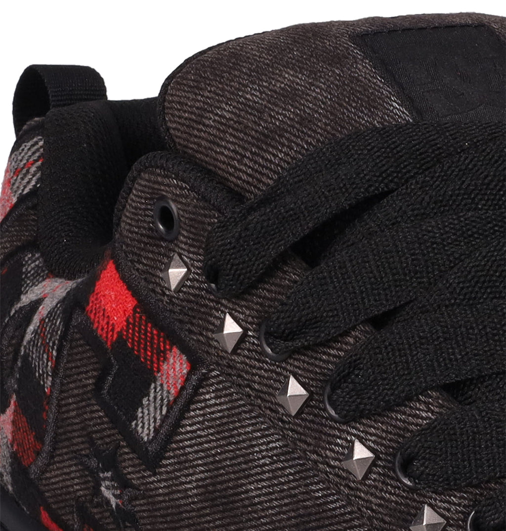 Close-up of DC Shoes Men's Court Graffik SE featuring premium upper materials, black laces and fabric, a red plaid pattern, silver pyramid studs on the side, plus a black padded tongue and back loop for style.