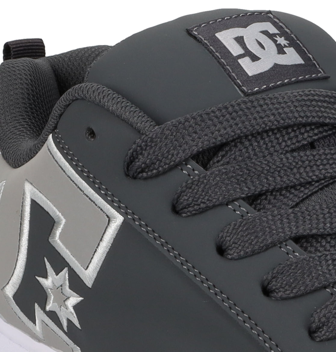 Close-up of a gray Men’s Court Graffik Special Edition Shoe by DC Shoes, featuring black laces and a silver DC Shoes logo design on the side, with detailed stitching, a puffy silhouette, and the signature DC Shoes logo on the tongue.