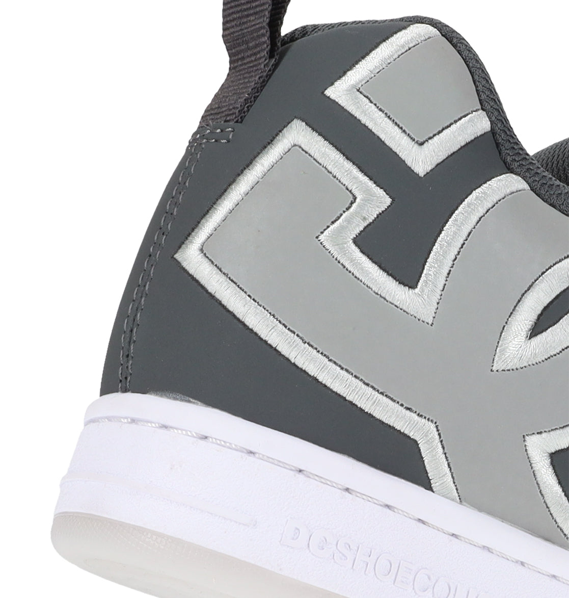 Close-up of the back and side of the DC Shoes Men’s Court Graffik Special Edition, a gray sneaker with a thick white sole and large, light gray stitched letters incorporated into the design—highlighting the signature puffy silhouette and bold DC logo that define this iconic style.