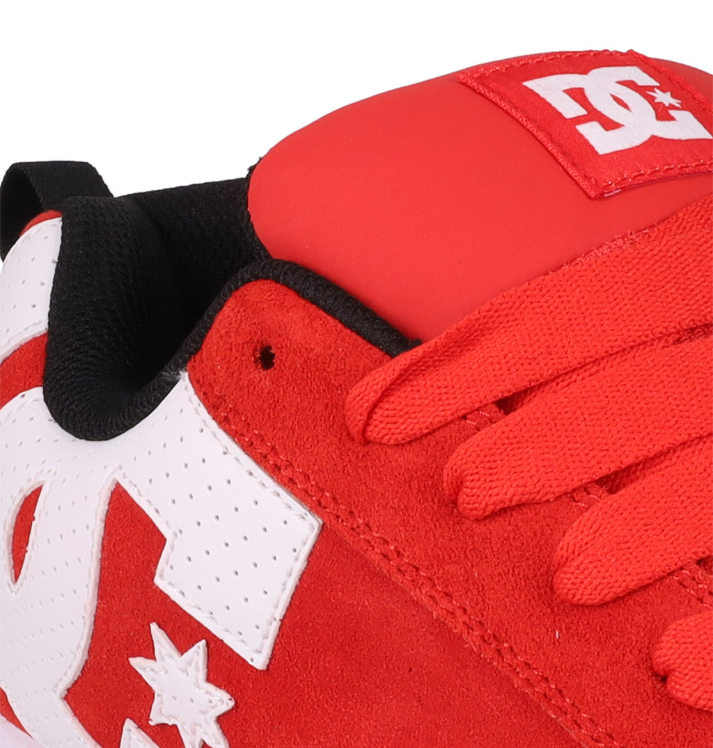 Close-up of DC Shoes Men's Court Graffik SE sneaker in red and white with red laces, a bold white DC logo on the side and tongue, puffy silhouette, black inner lining, and a suede and premium leather-like upper.
