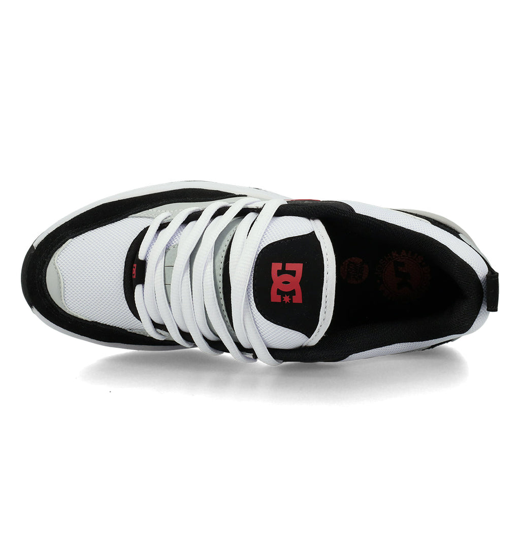 Men’s Ascend Skate Shoes by DC Shoes, shown from above, feature a white upper with black accents and white laces. Inspired by Josh Kalis and rooted in DC DNA, these sneakers display a red DC logo on the tongue and additional branding on the inner sole for modern comfort.