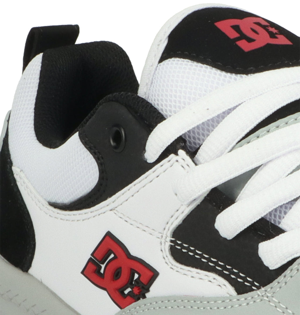 Close-up of the DC Shoes Men’s Ascend Skate Shoes in white and black, featuring a red DC logo, white laces, black inner lining, and visible stitching—channeling iconic DNA inspired by Josh Kalis and designed for modern comfort.