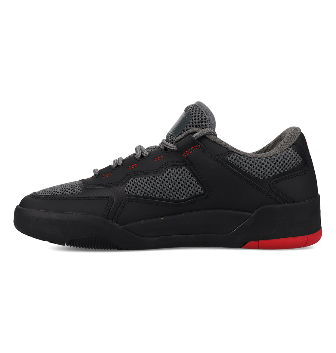The DC Shoes Men’s Metric features a black athletic design with gray mesh panels, gray laces, and a hint of red on the sole. These low-cut sneakers have a textured rubber outsole and are shown in a side profile view against a white background.
