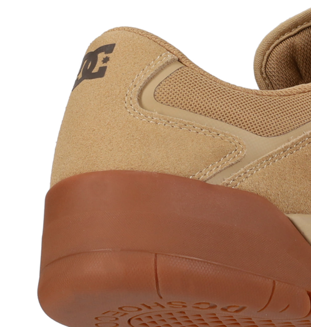 Close-up of the heel and upper side of the Men’s Metric Skate Shoes by DC Shoes in tan suede, featuring a brown rubber sole. The DC Shoes logo is displayed on the back of the heel, emphasizing its durable outsole designed for lasting wear.