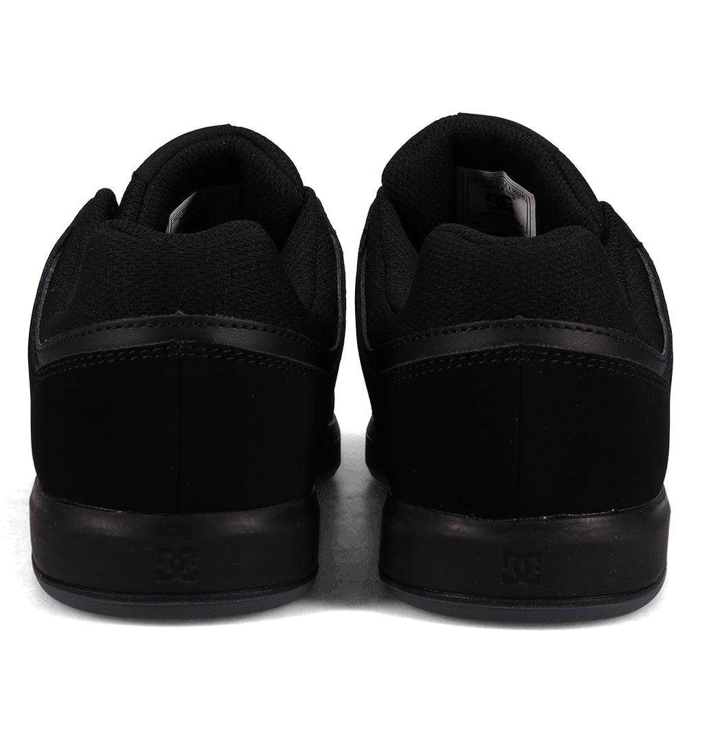 A pair of Men’s DC Cure Shoes by DC Shoes, featuring a black leather suede upper, displayed from the back and arranged side by side on a white background—ideal everyday footwear for any casual style.