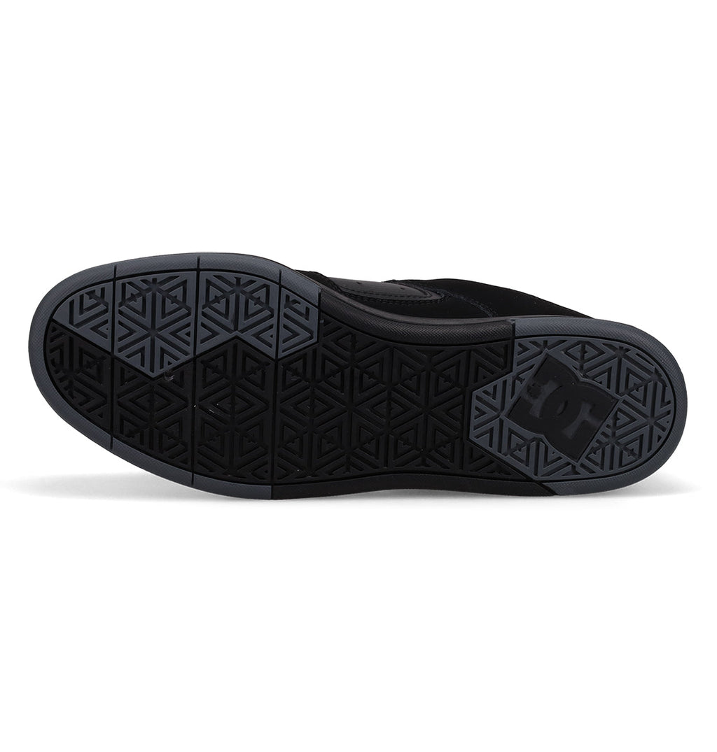 The image displays the black sole of the Men’s DC Cure Shoes by DC Shoes, featuring a geometric tread pattern and the signature DC logo near the heel—details that emphasize both durability and style. These shoes are ideal for everyday wear and often come with a premium leather suede upper.