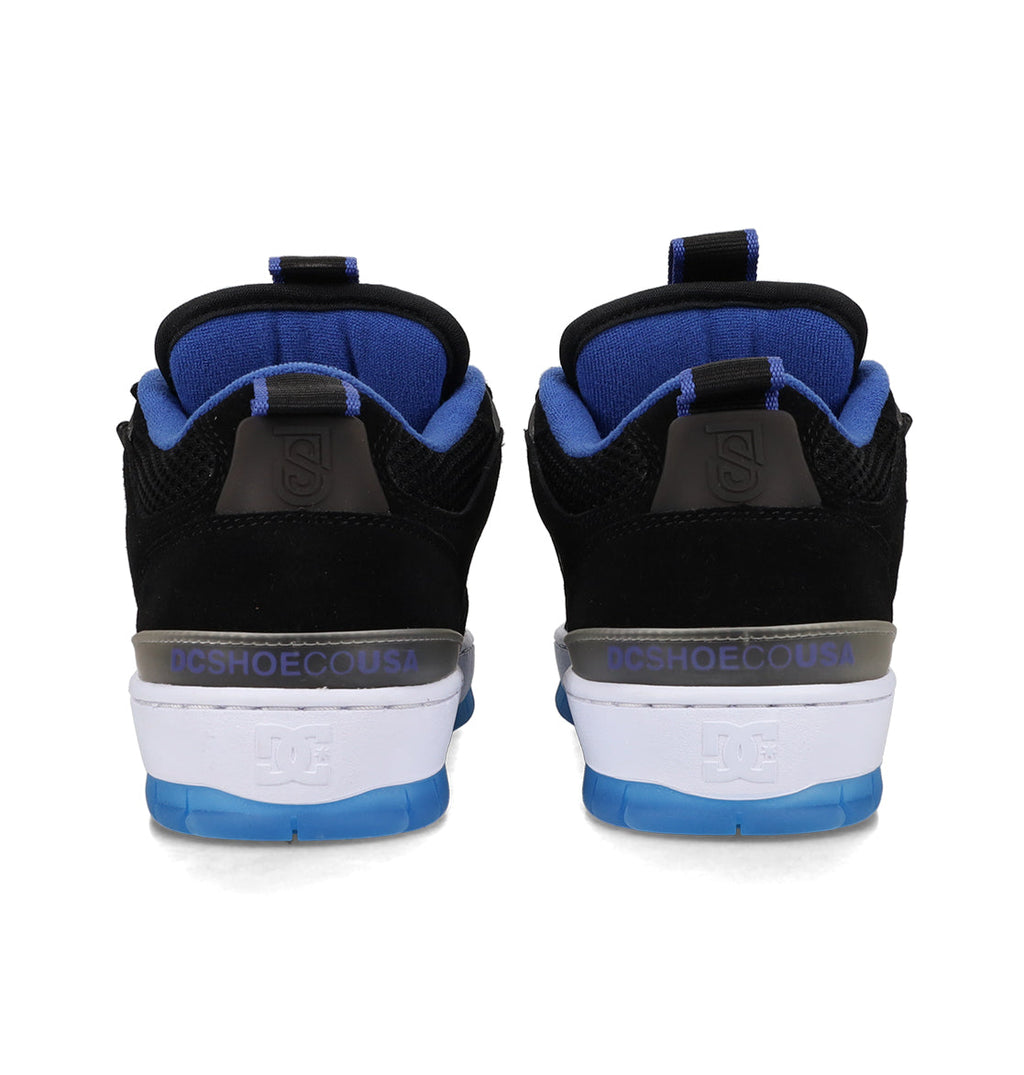 A pair of Men's JS-1 Shanahan Pro Skate Shoes by DC Shoes in black and blue, viewed from the back, displays the DCSHOECOUSA logo on the heel above a white and blue sole.