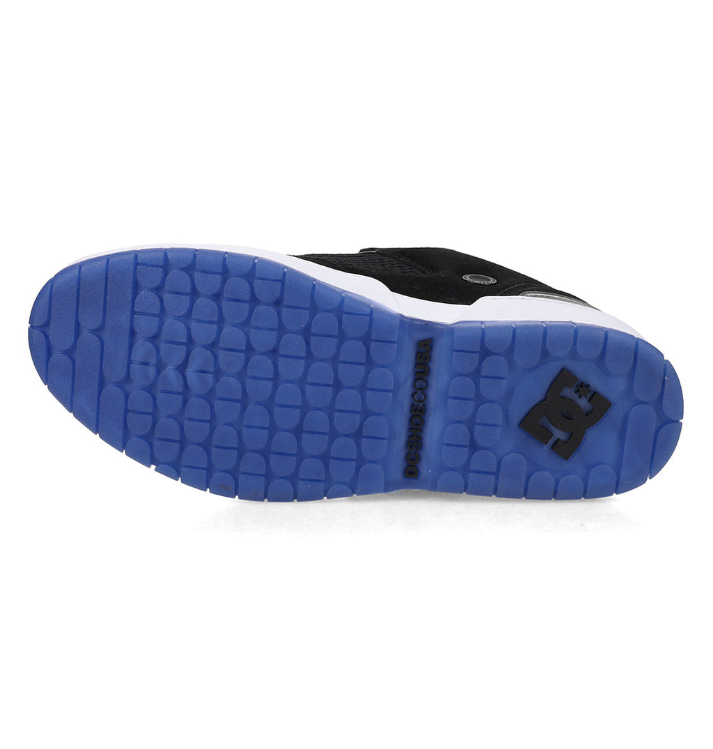 The Men’s JS-1 Shanahan Pro Skate Shoes by DC Shoes showcase a blue rubber DC Pill Pattern outsole with a textured grip, highlighted by a black DC Shoes logo and additional branding on the white midsole. The design is finished with a durable suede upper for enhanced style and support.