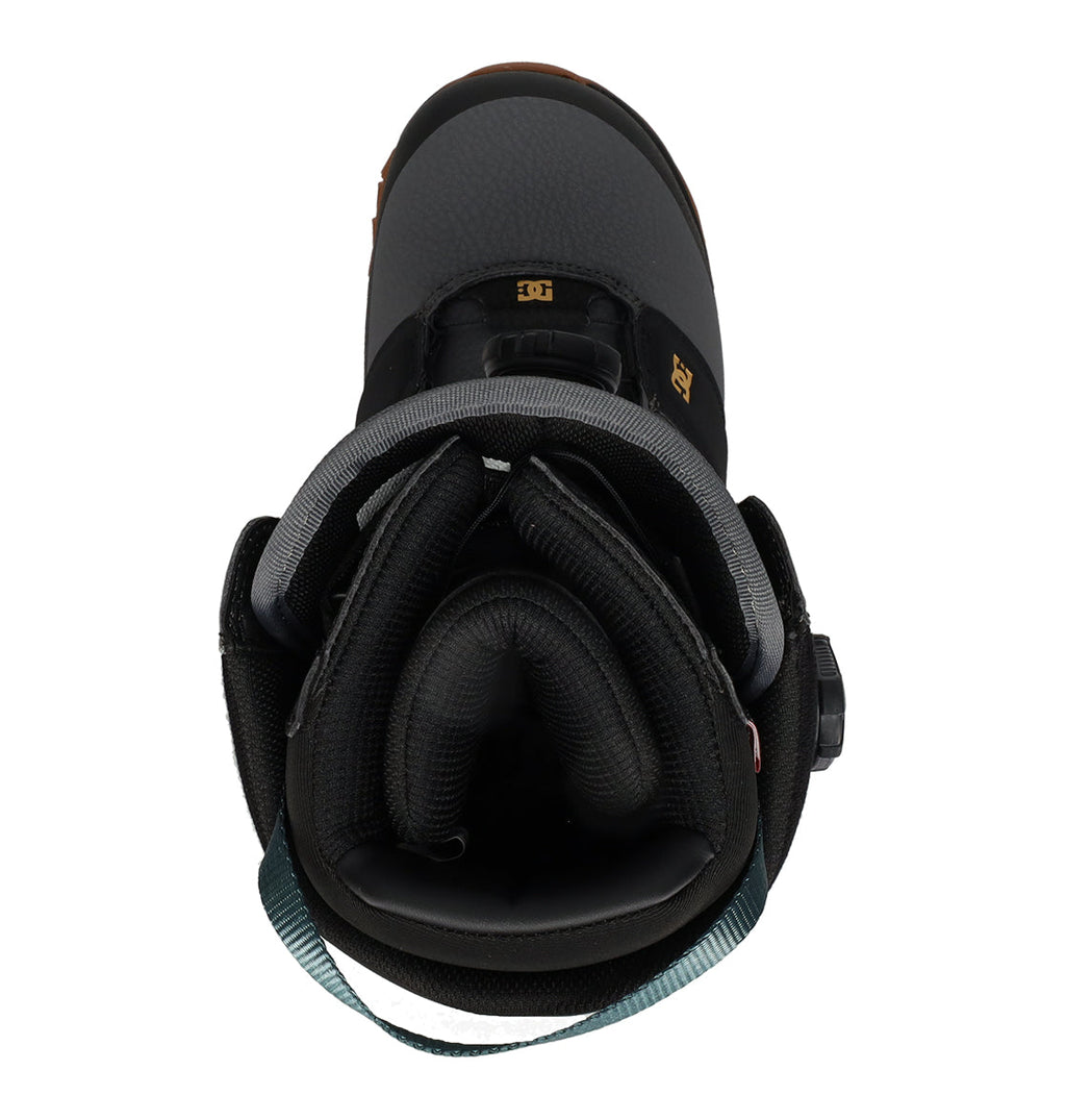 A top view of the DC Shoes Men’s Judge Snowboard Boots in black, featuring padded gray lining, a teal pull strap at the heel, and gold DC logos on the tongue and side—an ideal choice for quality-focused snowboarders.