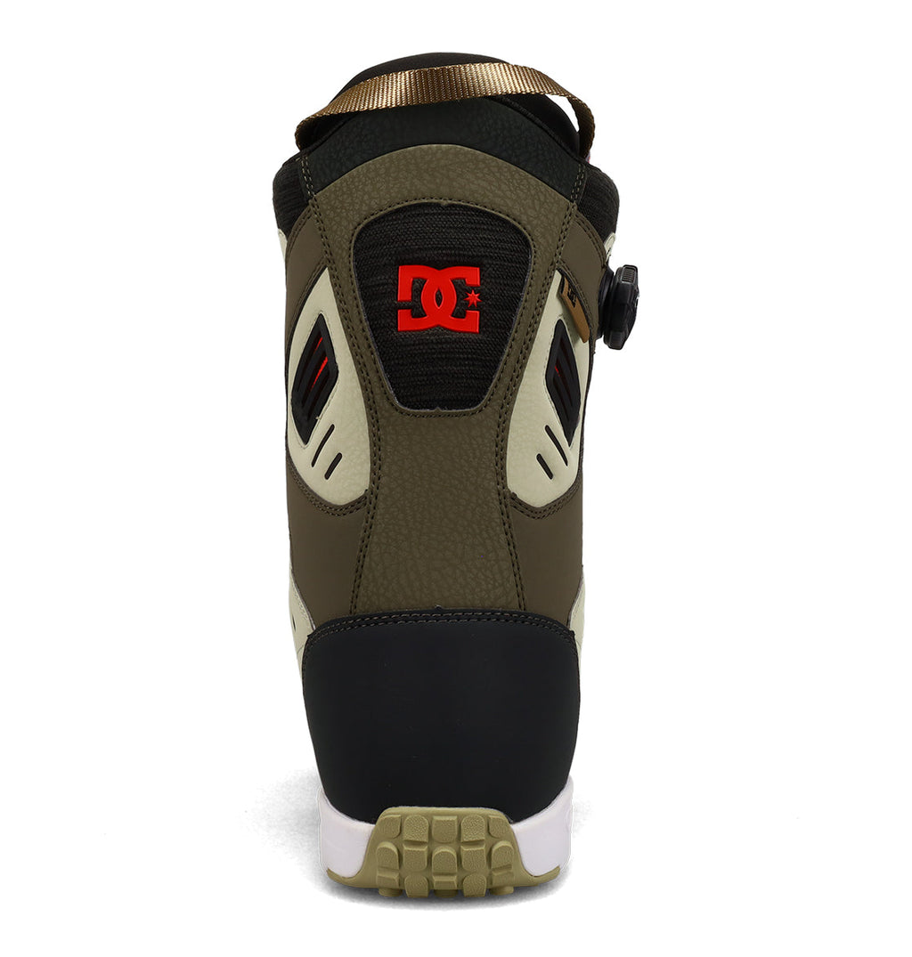 A rear view of the DC Shoes Men’s Judge Snowboard Boots in olive green, black, beige, and white, showcasing the red DC logo on the heel and a ridged beige outsole.