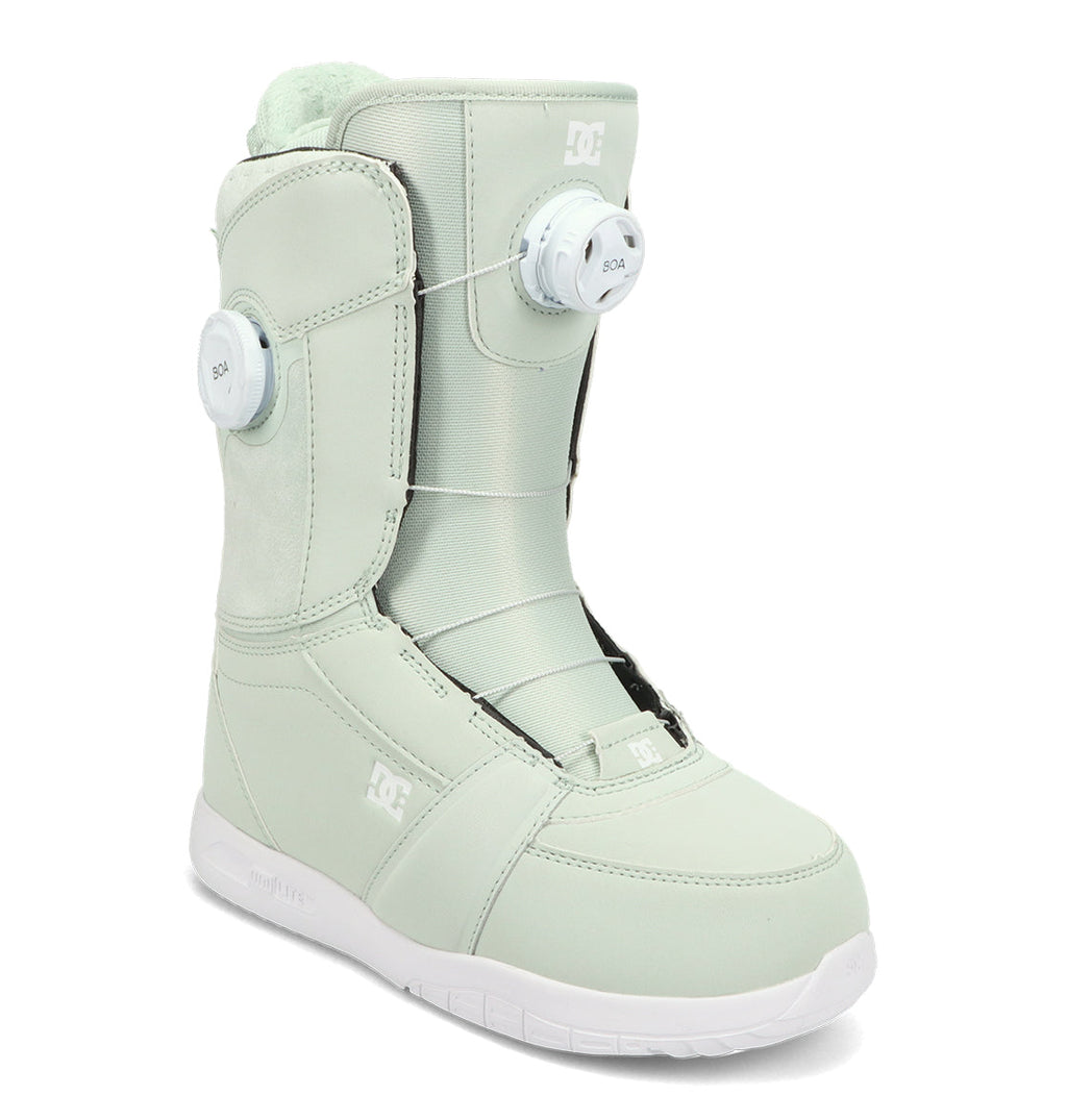 The DC Shoes Women’s Lotus Snowboard Boots in light mint green feature dual BOA dials for customizable tightening, exceptional comfort and support, a white sole, and a prominent DC logo on the side. The boots are displayed at an angle against a white background.