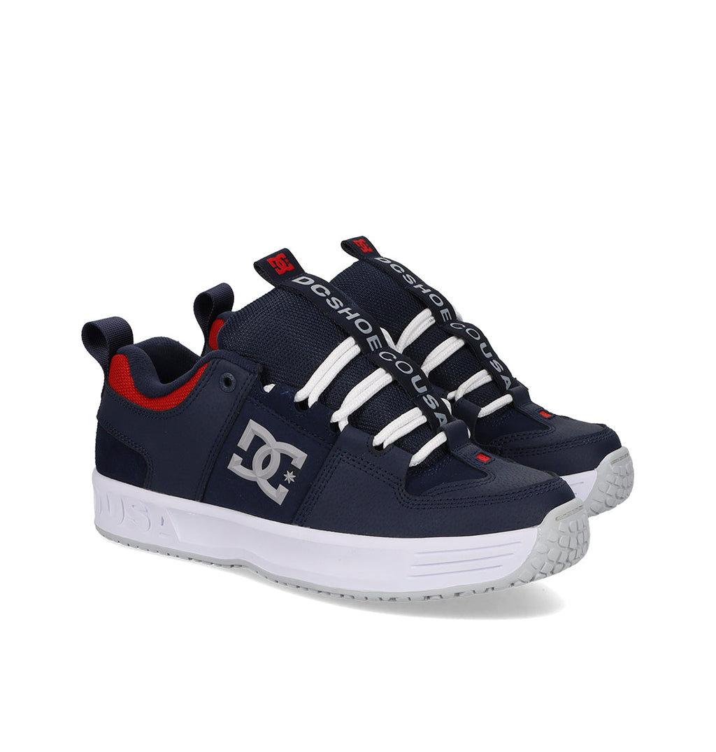 Navy blue sneakers with white soles and red accents on a white background