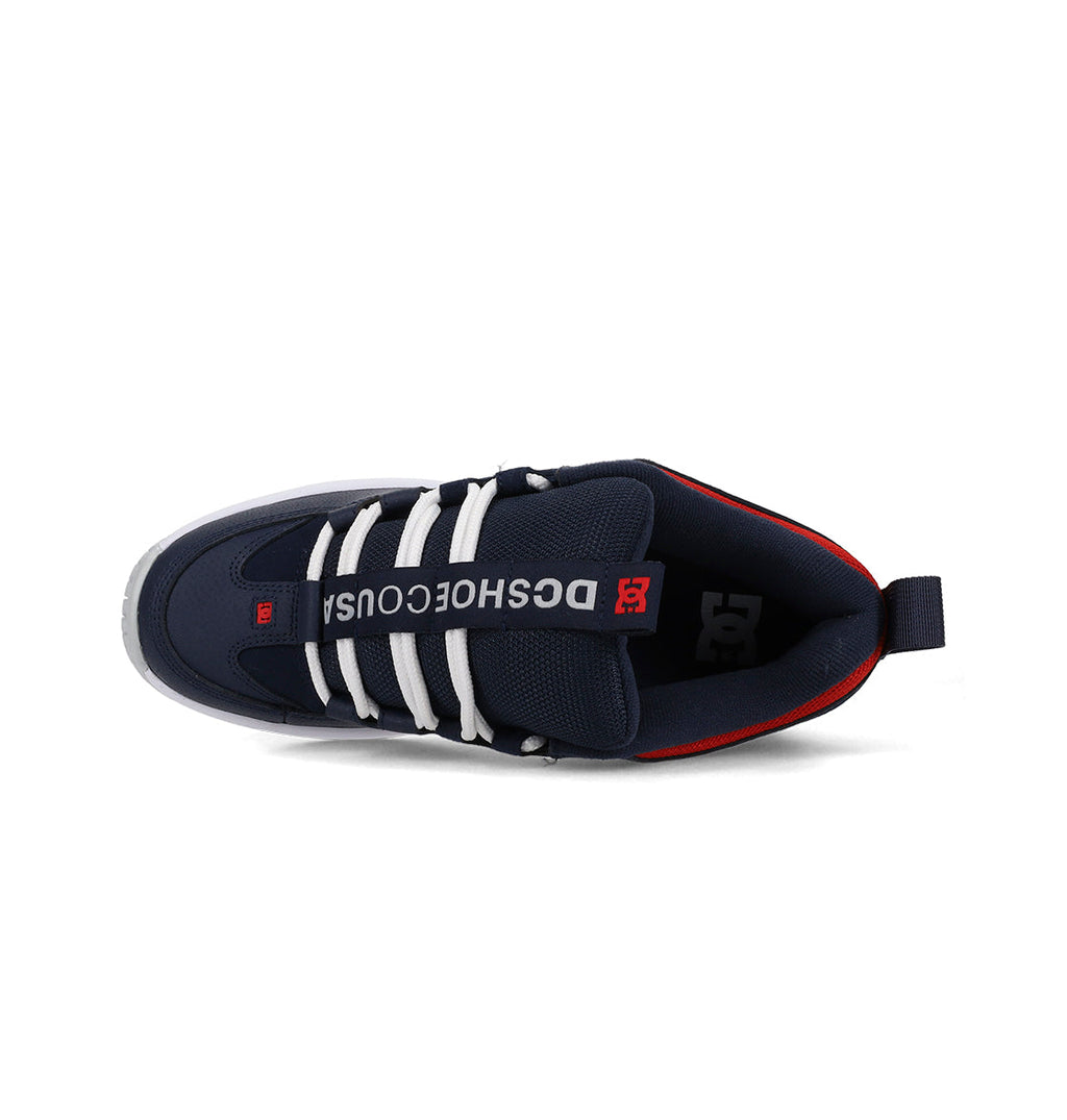 Navy blue athletic shoe with white stripes and red accents on a white background