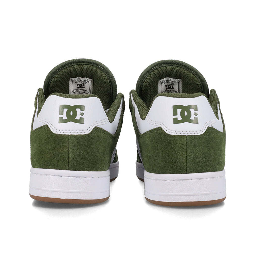 Rear view of a pair of green and white Men’s Manteca 4 Shoes by DC Shoes, featuring a suede texture, white midsoles, and brown outsoles. The performance-oriented design stands out, with the DC logo displayed on the back of each shoe.