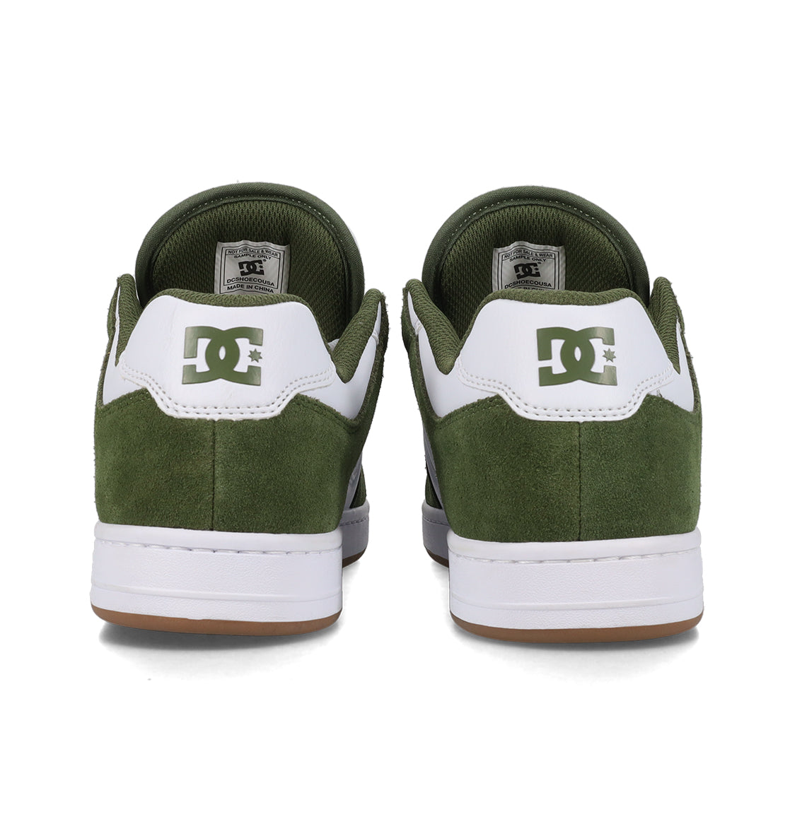 Rear view of a pair of green and white Men’s Manteca 4 Shoes by DC Shoes, featuring a suede texture, white midsoles, and brown outsoles. The performance-oriented design stands out, with the DC logo displayed on the back of each shoe.