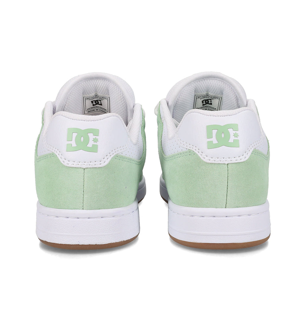 A pair of mint green and white Women’s Manteca 4 Shoes by DC Shoes are shown from the back, featuring the signature DC Shoes logo on each heel counter. The white soles with a brown bottom edge emphasize both the style and performance-driven design.