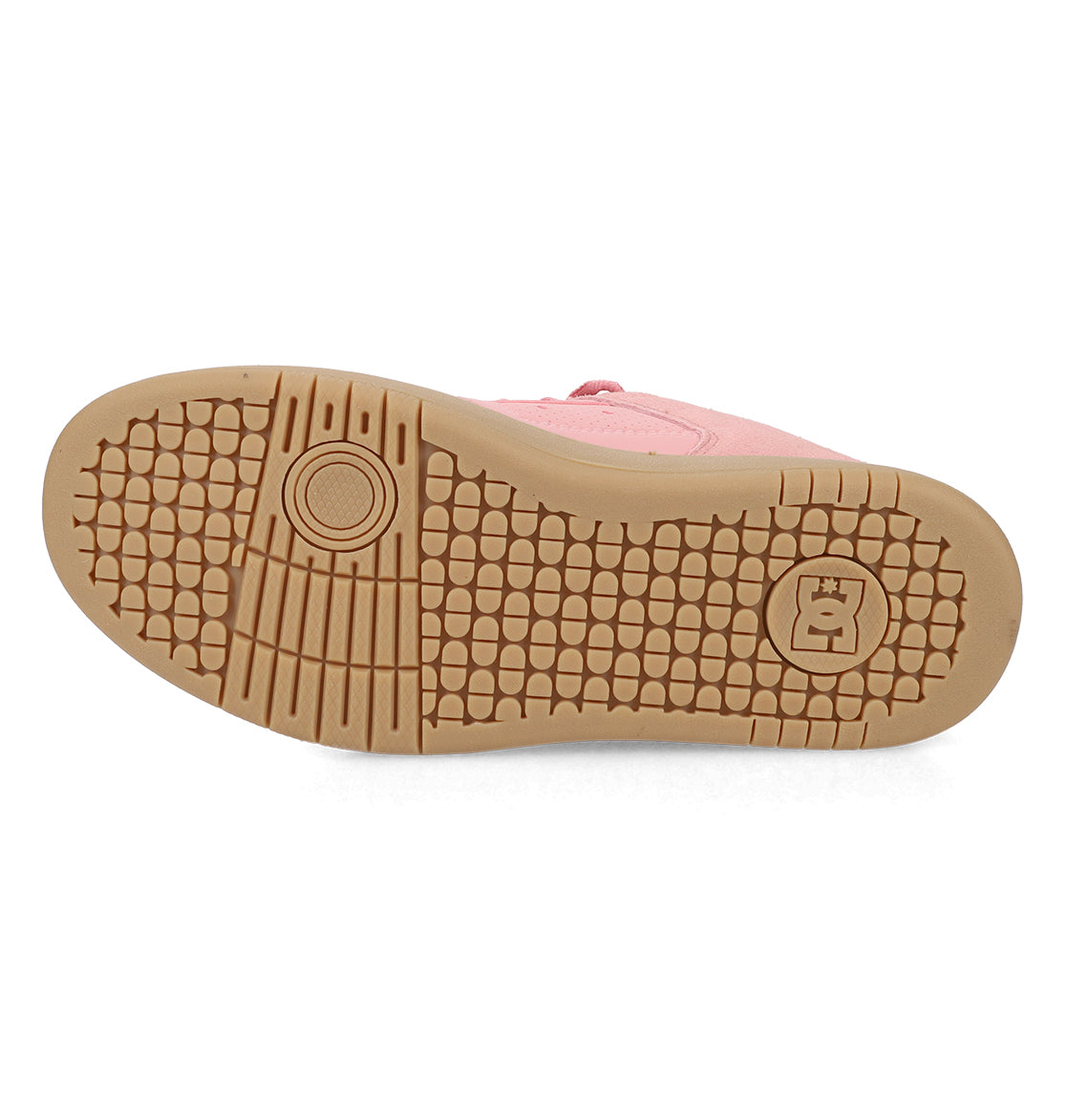 The image displays the light brown sole of a pink Women’s Manteca 4 Shoe by DC Shoes, featuring a textured, grid-like tread pattern and a circular logo near the heel that accentuates its classic style.