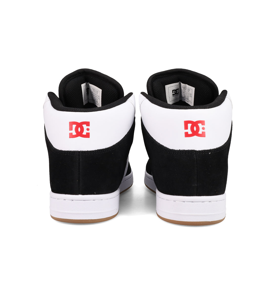 A pair of Men's Manteca 4 Hi Shoes by DC Shoes in black and white, seen from the back with a red DC logo on each heel and vintage high-top basketball-inspired details.