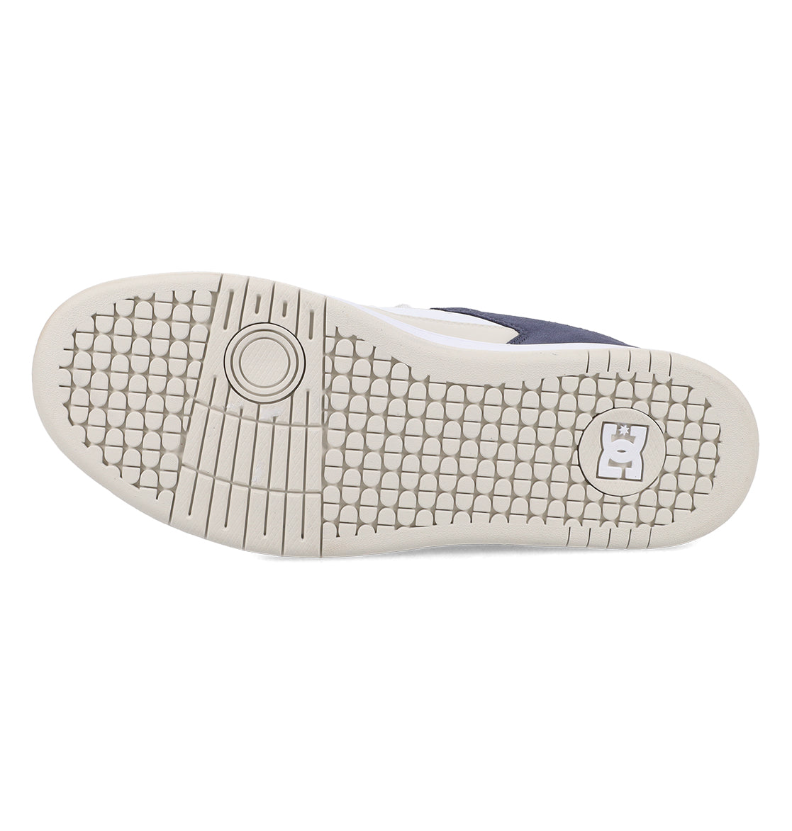 The image shows the sole of the Men’s Manteca 4 Shoes by DC Shoes, featuring a textured hexagonal pattern, a circular design near the toe, and a DC logo near the heel. The light-colored sole highlights the performance-focused design typical of high-quality skate footwear.