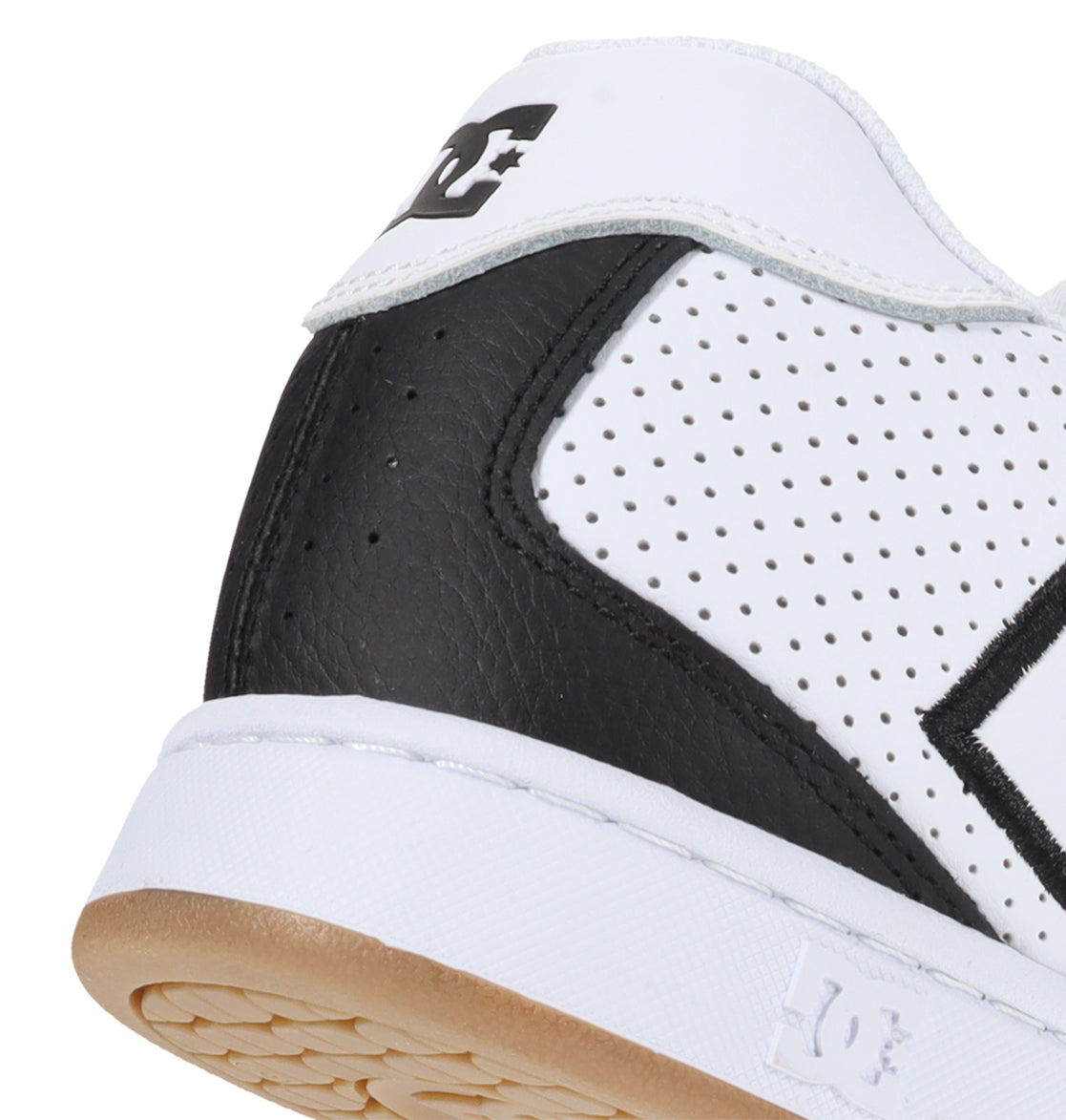 Close-up of the heel and side of a white DC Shoes Men’s Net Shoe, showcasing black panels, perforated detailing, and a tan sole. Constructed from durable materials, this puffy sneaker displays the DC Shoes branding near the ankle and on the midsole.