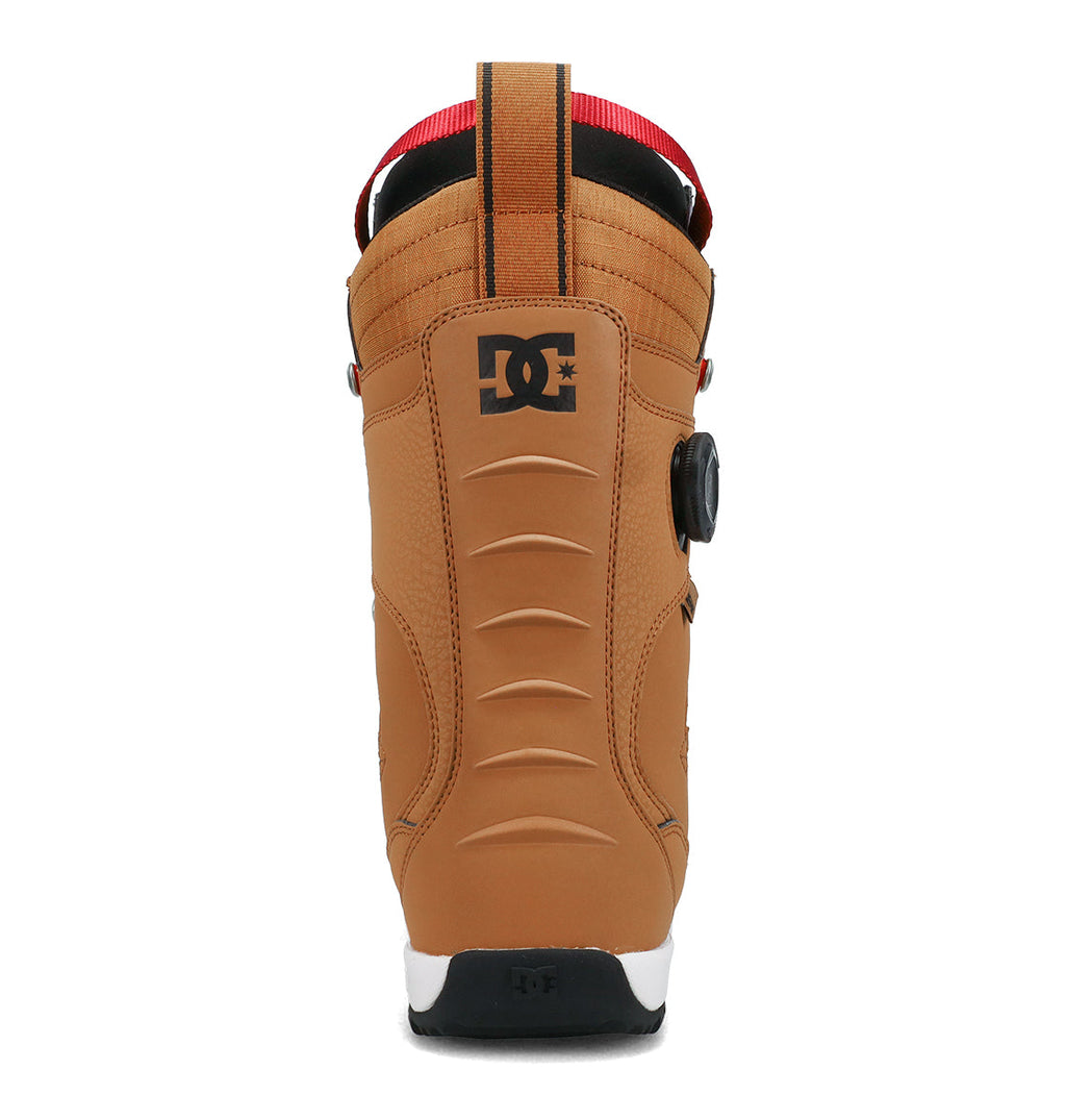 A tan DC Shoes Men’s Premier Hybrid Snowboard Boot shown from the back, featuring a black DC logo near the top, a red pull loop, and a white and black sole.