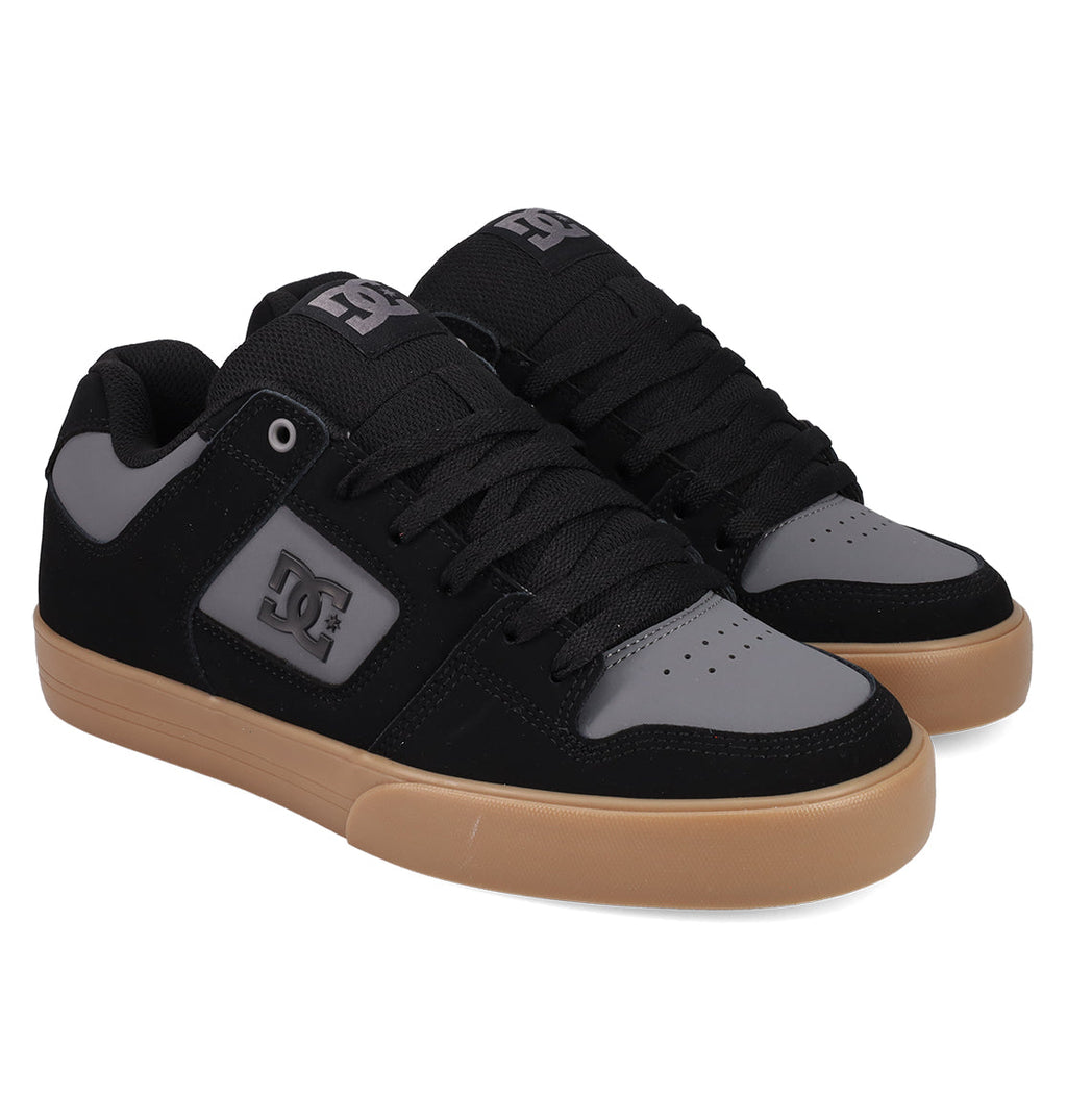 DC Shoes Men's Pure Shoes feature black and gray uppers, black laces, a gray side logo, and light brown rubber soles. These comfortable sneakers are displayed on a white background.