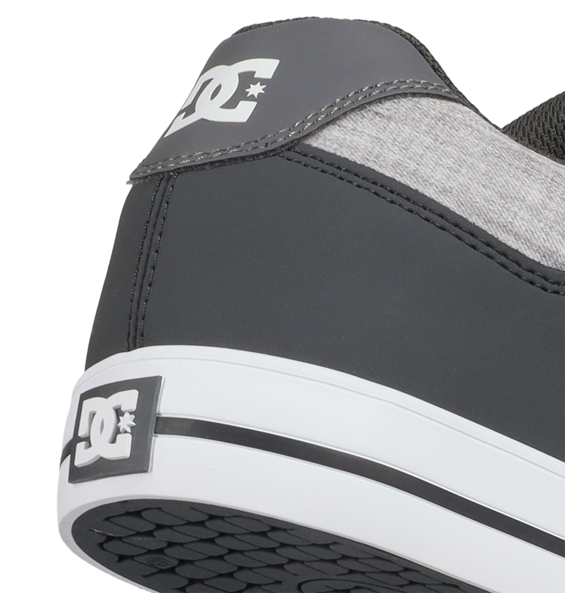 Close-up of the heel of a dark gray and light gray pair of Men’s Pure Shoes by DC Shoes, featuring the iconic DC logo on the back and sole, with a white midsole and black outsole pattern—an ideal choice for men’s shoe collections seeking comfortable and versatile everyday footwear.