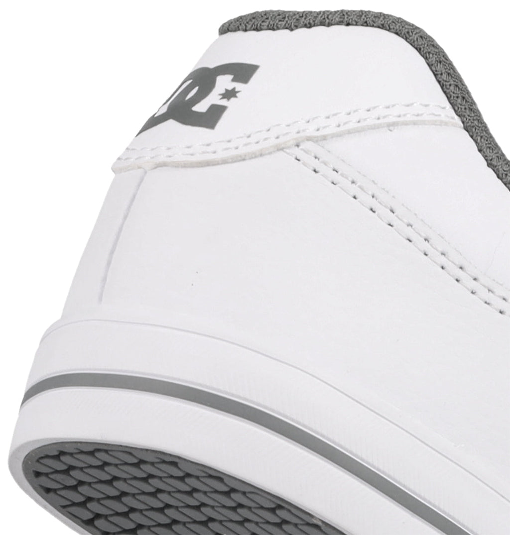Close-up of the heel of the DC Shoes Kids’ Pure Shoes, featuring a white upper with gray accents, a gray patterned sole, and the DC Shoes logo in gray on the back. Built for durability as kids’ skate shoes, these sneakers also provide comfortable everyday wear.
